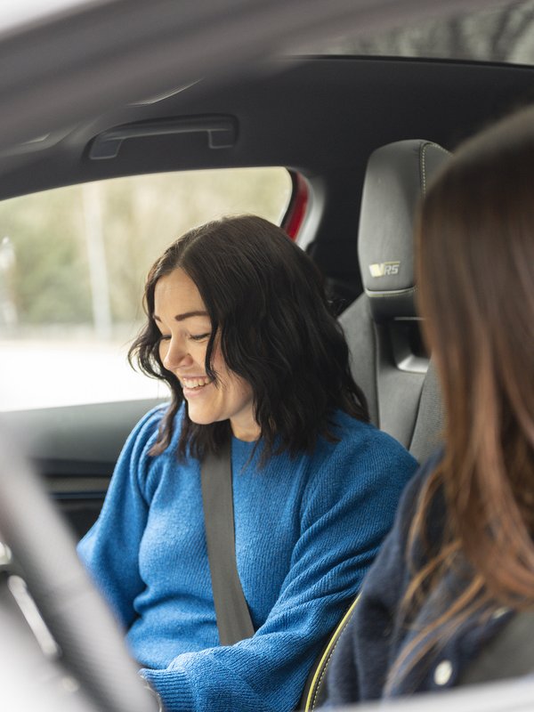 trafikklærer smiler i bil med elev